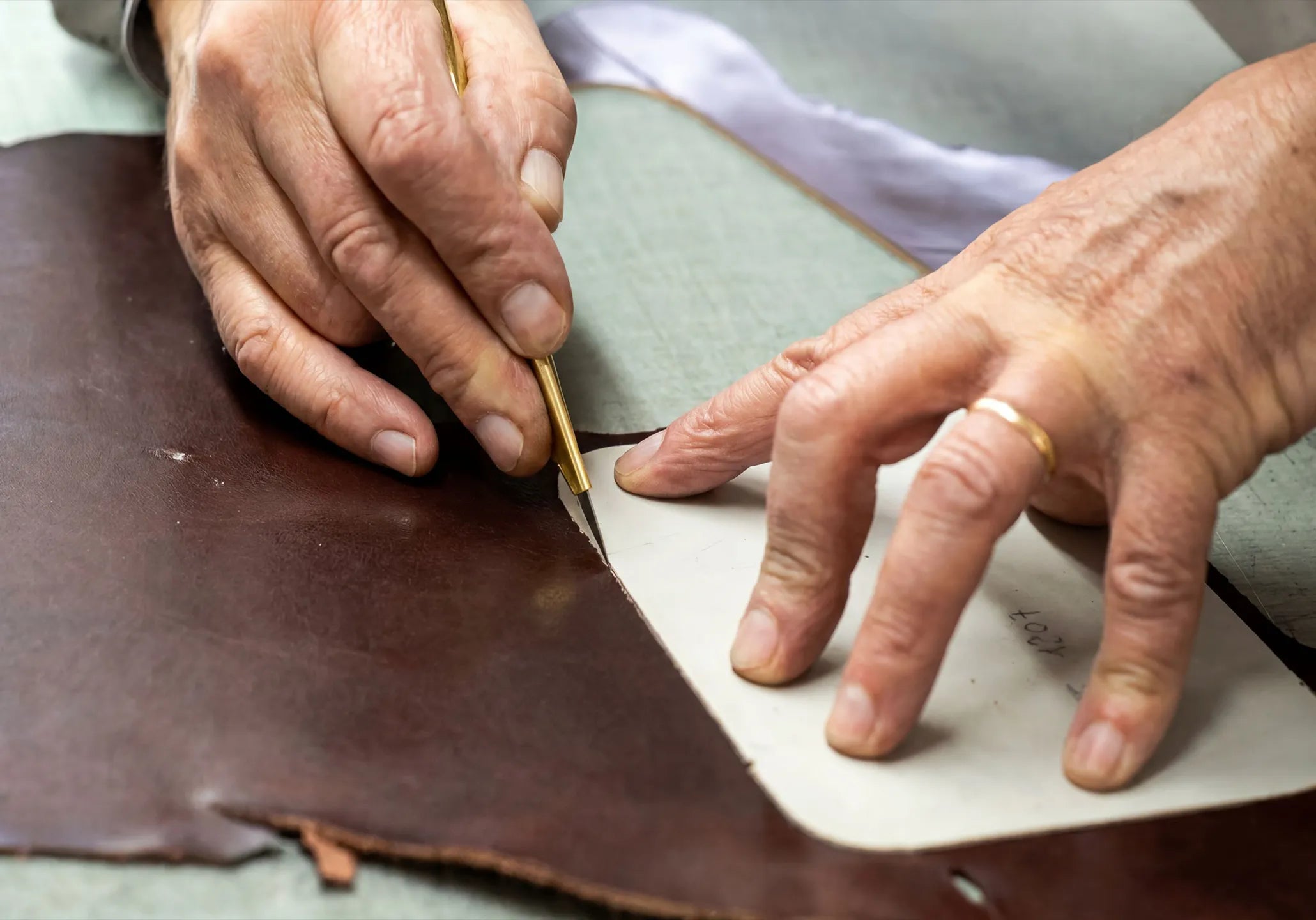 Handgefertigte Fertigung einer Mornin' Glory Ledertasche für Rasierer durch präzises Zuschneiden von hochwertigem Echtleder.